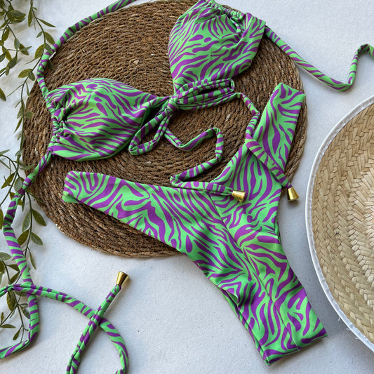 Green and purple zebra print bikini top and bottom on a light background